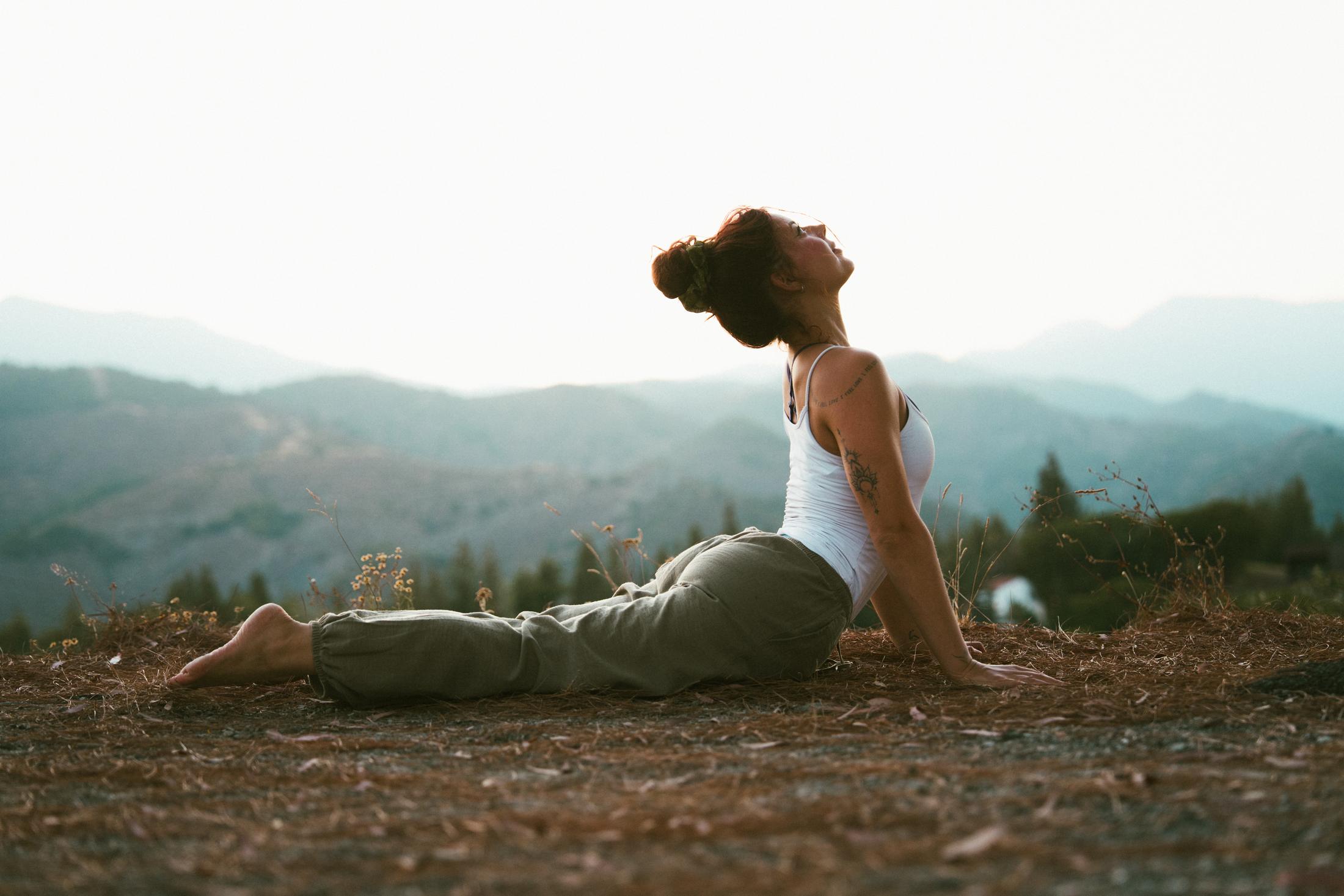 Rosa in upward-facing dog on a mountain ridge at golden hour
